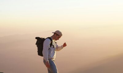 A traveler standing on a mountain peak with a backpack.