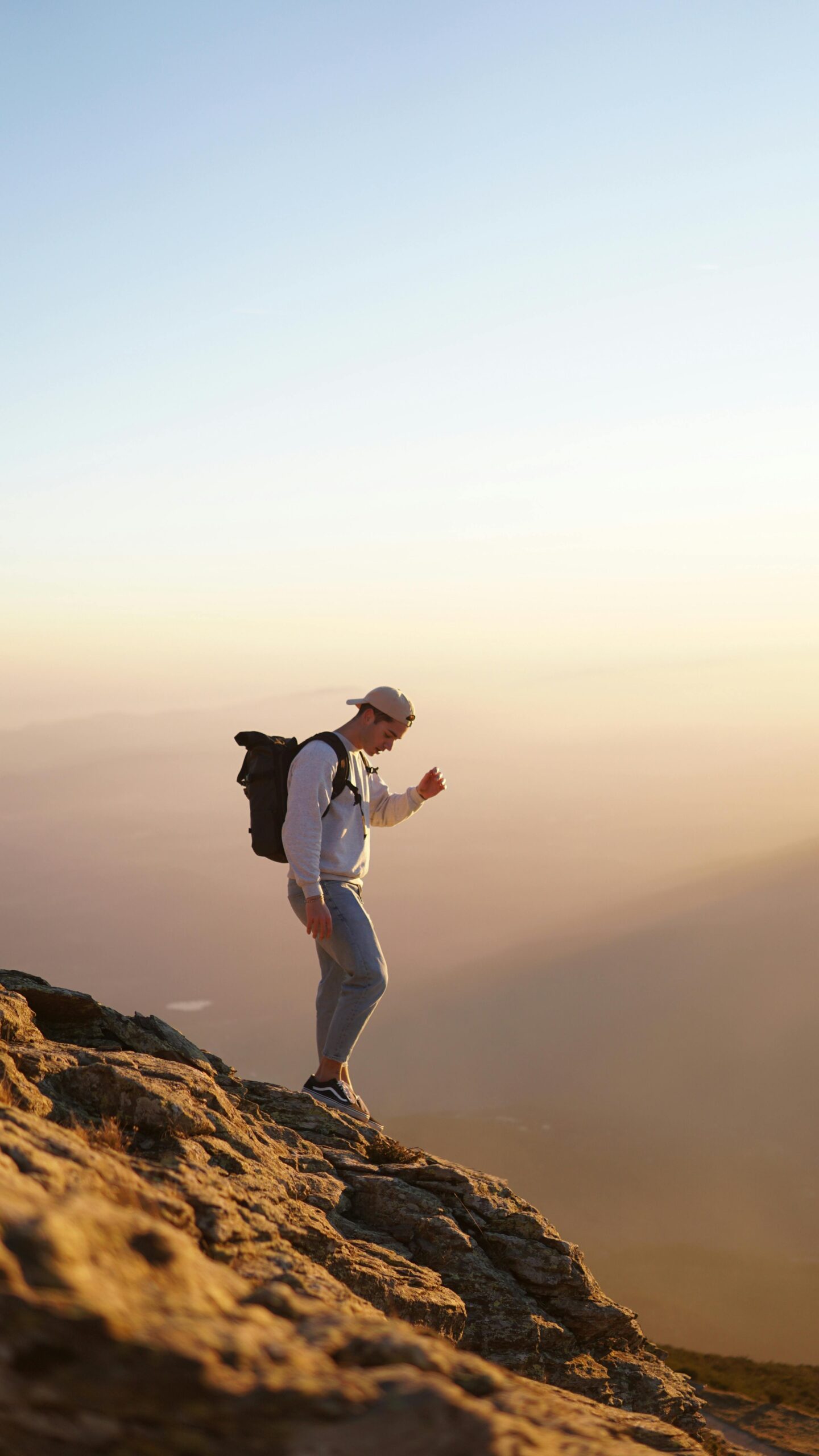 A traveler standing on a mountain peak with a backpack.
