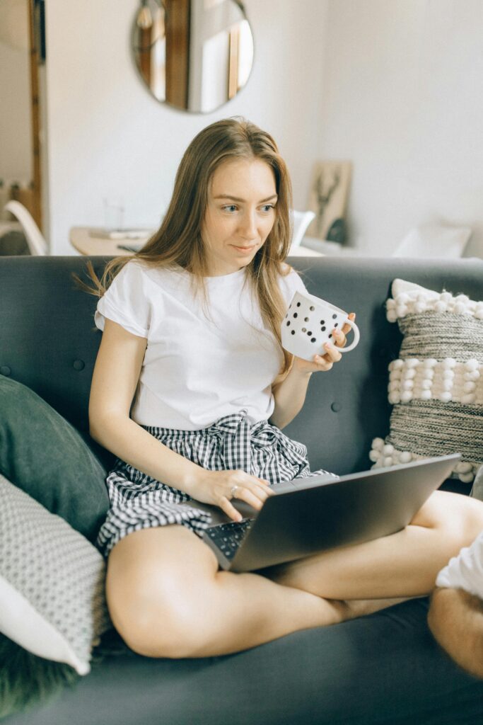 Employee working from home with a laptop and coffee mug.