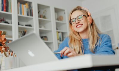 A professional desk with a laptop, webcam, and headphones.