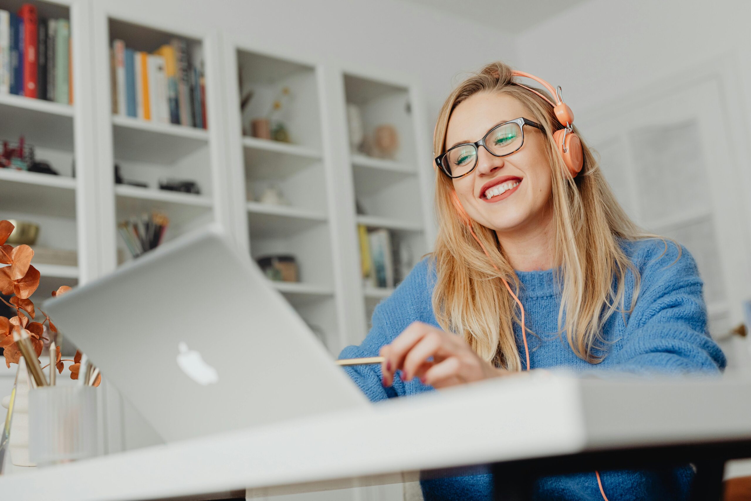 A professional desk with a laptop, webcam, and headphones.