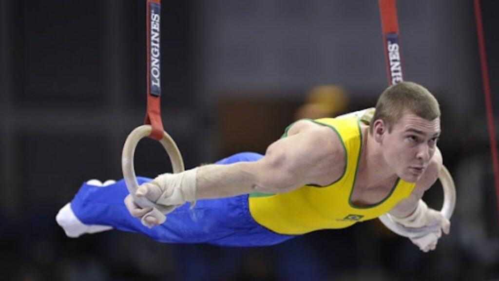 A gymnast on still rings showing strength.