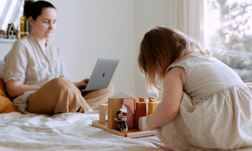 Person balancing work laptop on one side and family time on the other.