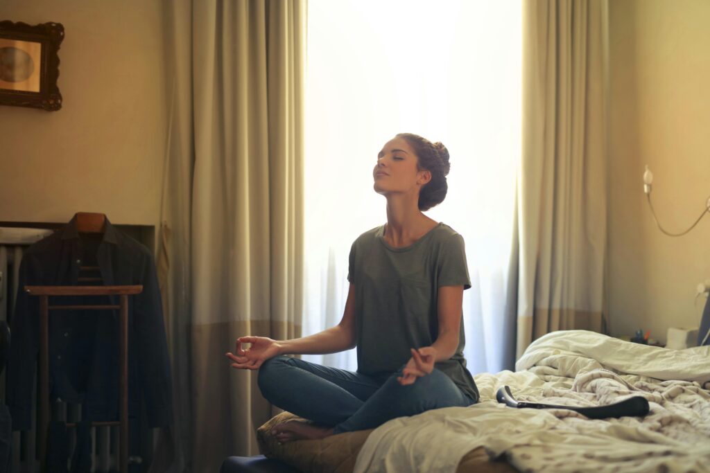 Person meditating or doing breathing exercises before bed.