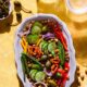 A vibrant bowl of salad with kale, spinach, and colorful veggies.
