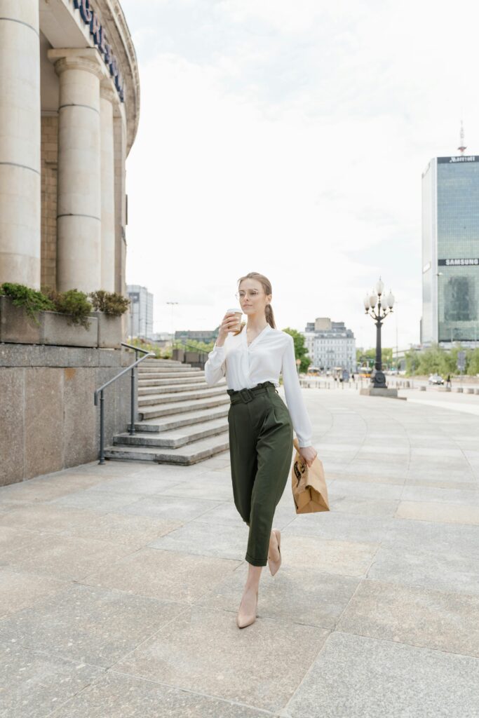 A confident woman in a tailored blazer and trousers walking into an office.