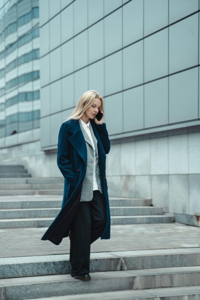 A confident woman in a tailored blazer and trousers walking into an office.