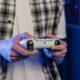 A player holding a bat and a game controller together.