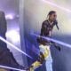 Travis Scott performing under vibrant lighting.