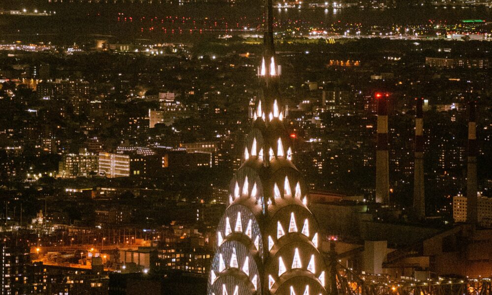 The building lit up at night with its glowing crown.