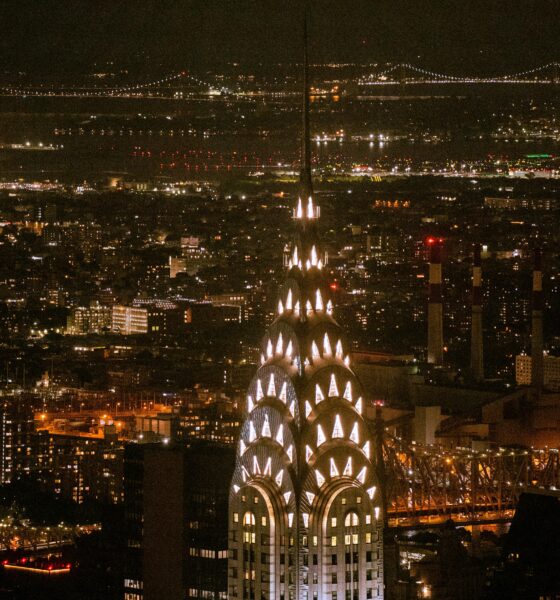The building lit up at night with its glowing crown.