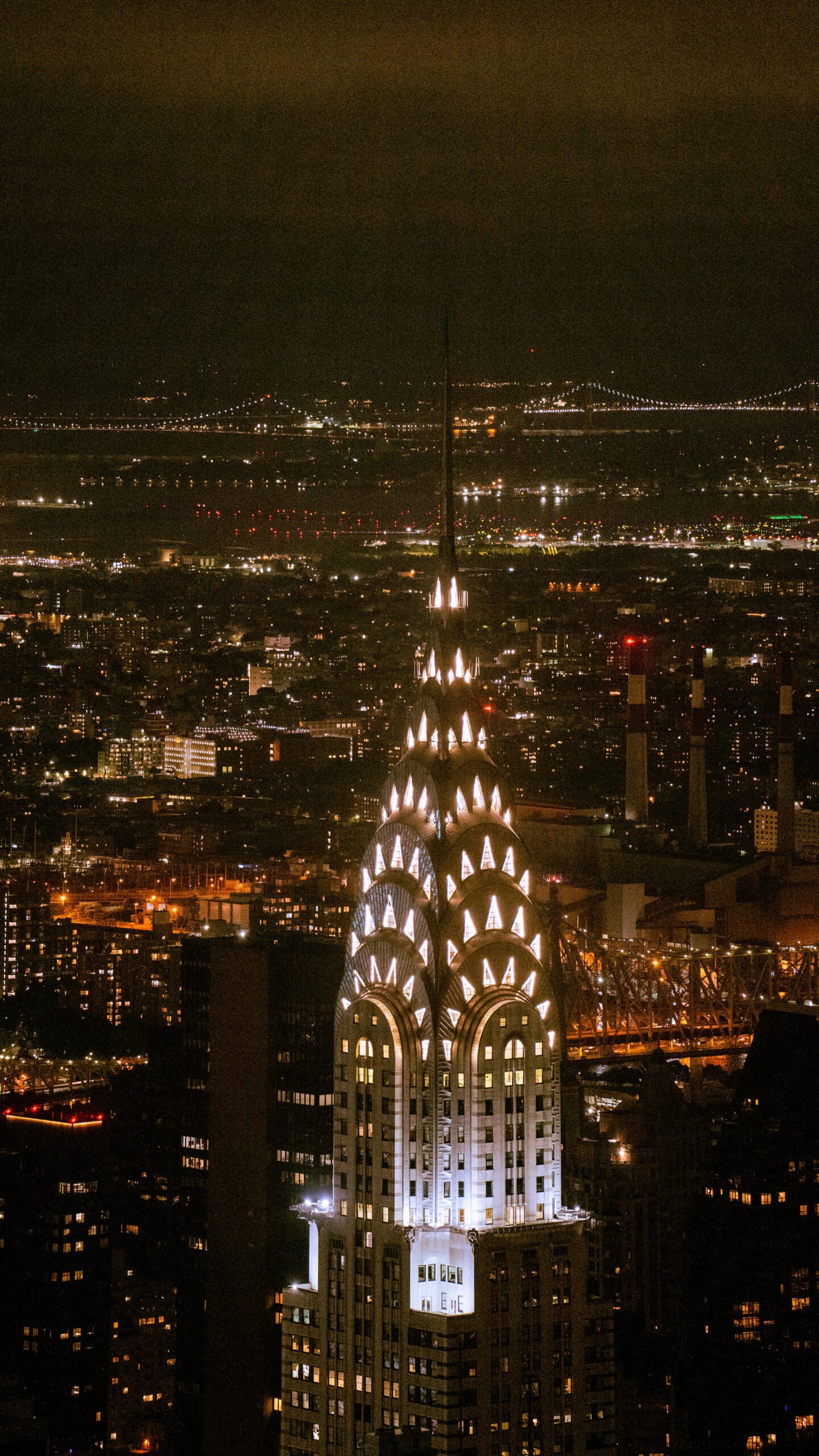 The building lit up at night with its glowing crown.