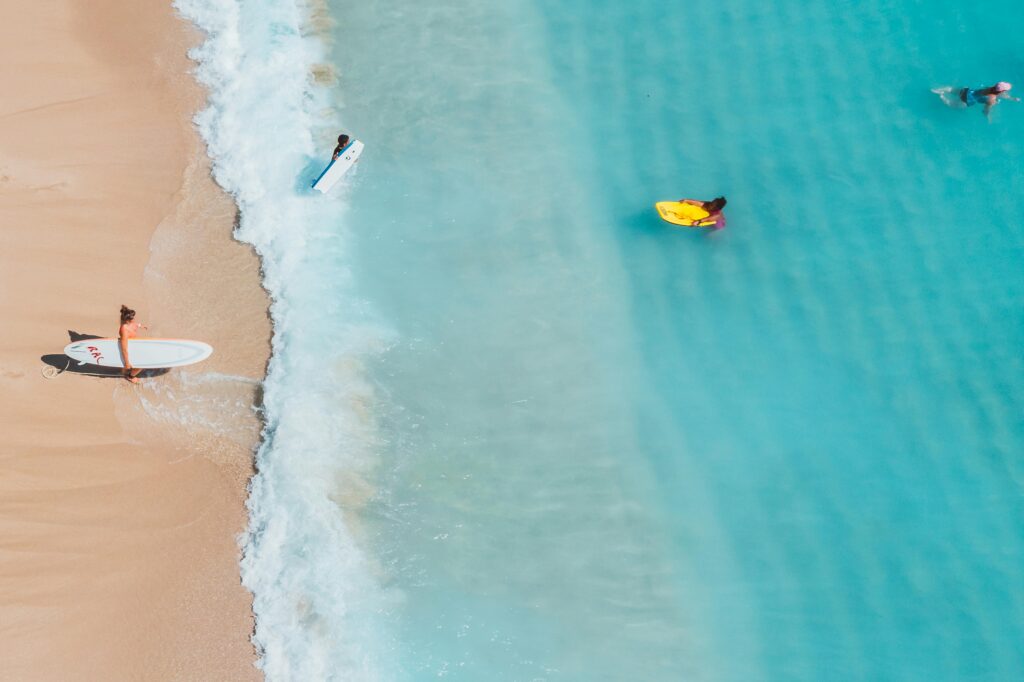Aerial view of turquoise ocean water with white sand beach.