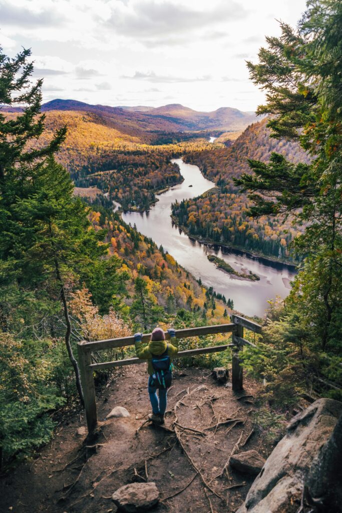 A stunning mountain landscape with hikers trekking on a trail at sunrise.