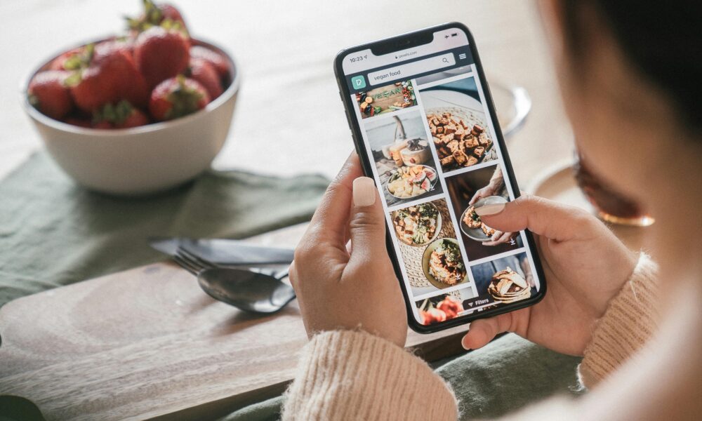 Young person using a smartphone to order fast food via app.